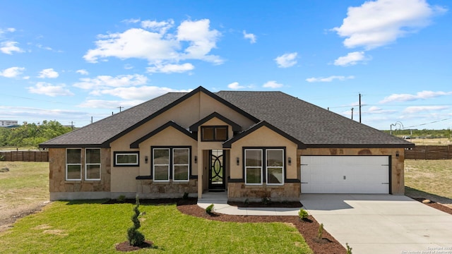view of front of home featuring roof with shingles, fence, a garage, and stone siding