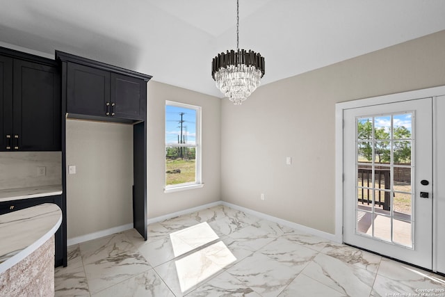 unfurnished dining area with baseboards, a chandelier, lofted ceiling, and marble finish floor