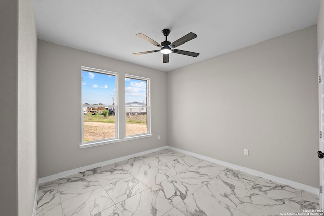 unfurnished room with baseboards, ceiling fan, and marble finish floor