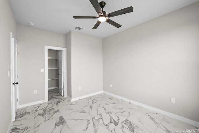 unfurnished bedroom featuring baseboards, visible vents, a spacious closet, and marble finish floor
