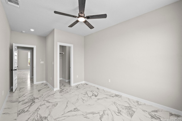 unfurnished bedroom featuring ceiling fan, a walk in closet, marble finish floor, baseboards, and visible vents