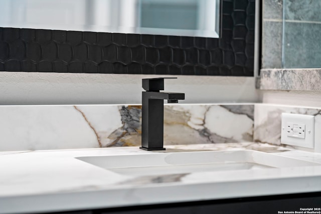 interior details featuring decorative backsplash and a sink