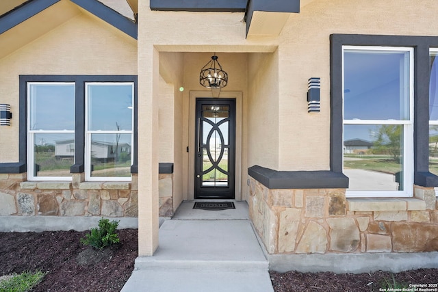 view of exterior entry with stucco siding and stone siding