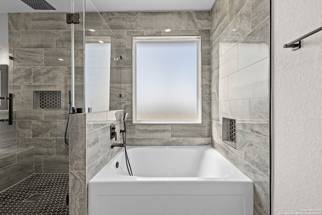 bathroom with a shower stall and a garden tub
