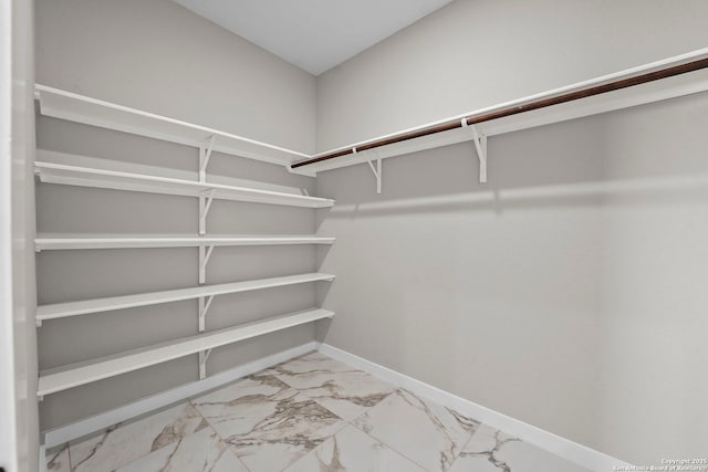 walk in closet with marble finish floor
