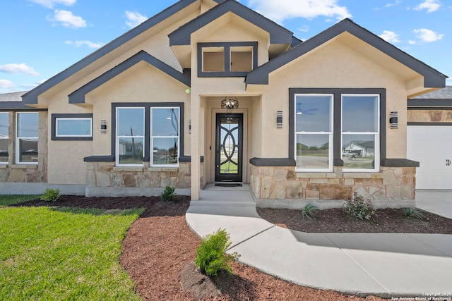 view of front of property featuring a garage, stucco siding, a front yard, and stone siding