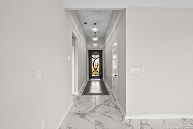 doorway featuring baseboards and marble finish floor