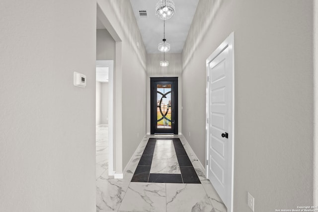 entryway with baseboards, visible vents, and marble finish floor