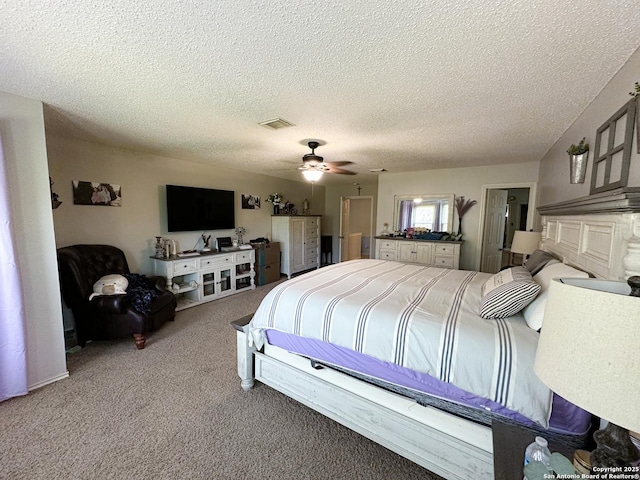 carpeted bedroom featuring ceiling fan, a textured ceiling, and visible vents