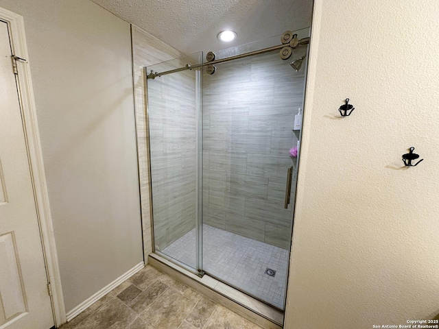 bathroom with baseboards, a stall shower, recessed lighting, and a textured ceiling
