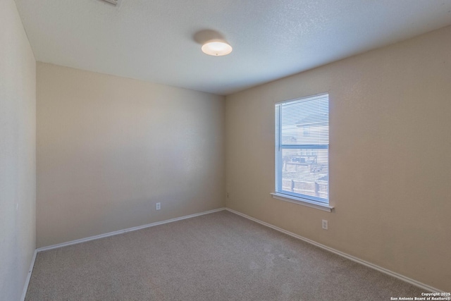 carpeted spare room with baseboards