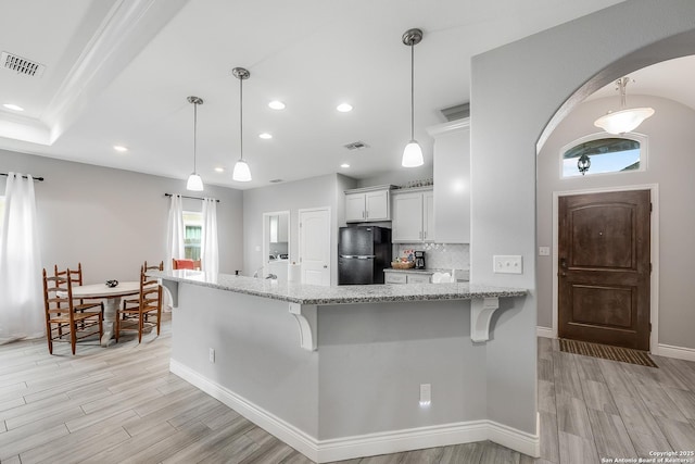 7186 Lake Placid, Corpus Christi, TX 78414 - kitchen featuring freestanding refrigerator, a breakfast bar, light wood-style flooring, and visible vents