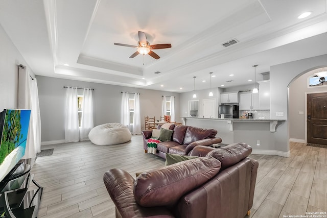 7186 Lake Placid, Corpus Christi, TX 78414 - living area with a ceiling fan, visible vents, arched walkways, a raised ceiling, and light wood-style floors