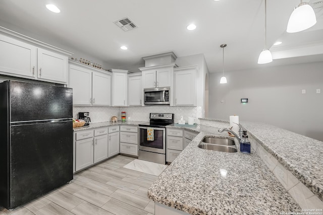 7186 Lake Placid, Corpus Christi, TX 78414 - kitchen featuring backsplash, visible vents, appliances with stainless steel finishes, a sink, and a peninsula