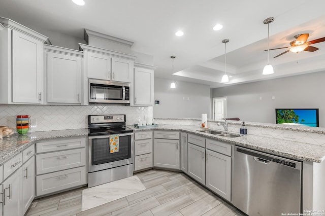 7186 Lake Placid, Corpus Christi, TX 78414 - kitchen with appliances with stainless steel finishes, a sink, a peninsula, decorative light fixtures, and tasteful backsplash