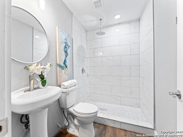 1851 Dawson St, San Antonio, TX 78202 - full bathroom with visible vents, wood finished floors, toilet, and tiled shower
