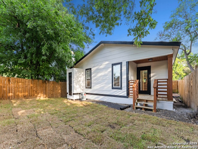 1851 Dawson St, San Antonio, TX 78202 - rear view of house with a fenced backyard, a yard, and covered porch