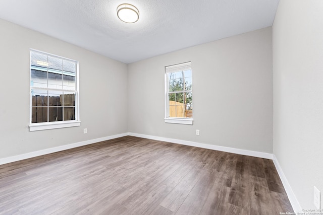 1851 Dawson St, San Antonio, TX 78202 - unfurnished room featuring wood finished floors, baseboards, and a textured ceiling