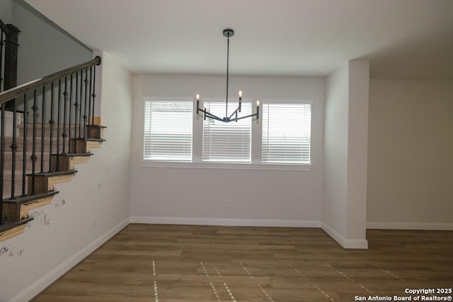 2707 Wild Skies, San Antonio, TX 78245 - unfurnished dining area featuring an inviting chandelier, baseboards, and wood finished floors