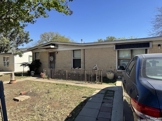 view of front of house with brick siding and fence