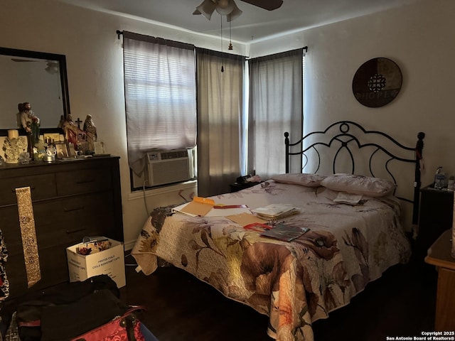 bedroom featuring a ceiling fan, wood finished floors, and multiple windows