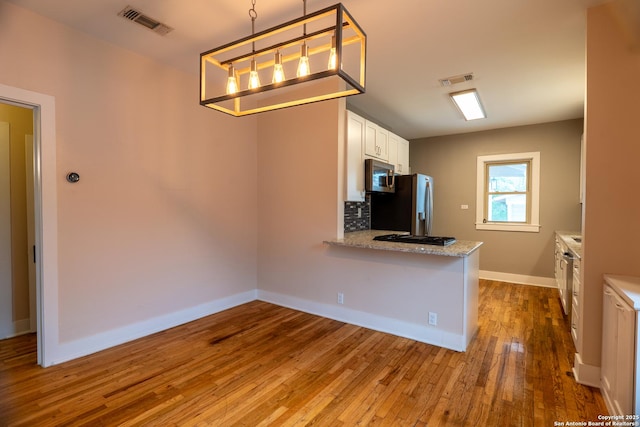 kitchen featuring stainless steel appliances, baseboards, white cabinetry, visible vents, and hardwood / wood-style flooring
