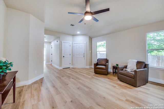 sitting room featuring a ceiling fan, visible vents, a wealth of natural light, and light wood-type flooring
