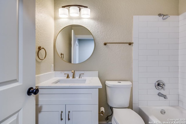 full bath with vanity, a textured wall, toilet, and shower / tub combination