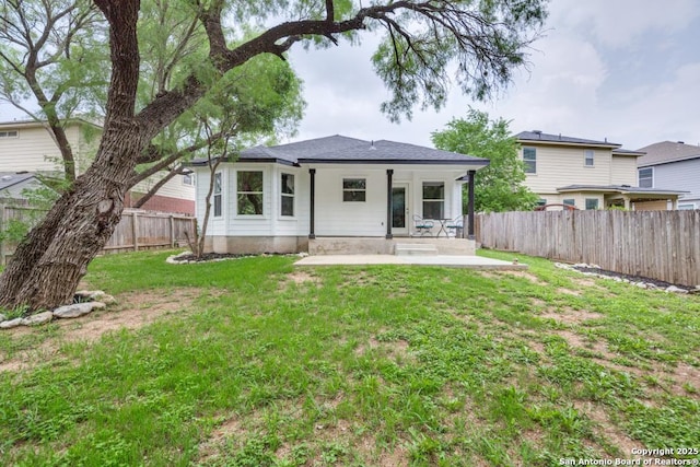 rear view of house with a patio, a fenced backyard, and a yard