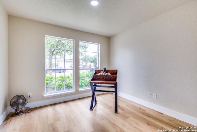 sitting room featuring a textured ceiling, baseboards, and wood finished floors