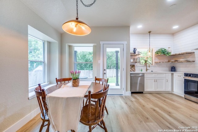 dining room with recessed lighting, baseboards, and light wood finished floors