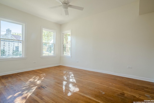spare room with baseboards, plenty of natural light, and a ceiling fan