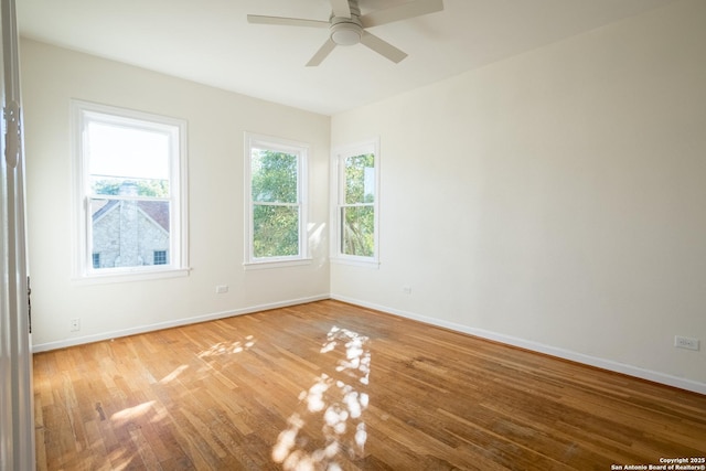 spare room featuring baseboards, ceiling fan, and light wood-type flooring