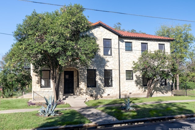 mediterranean / spanish home featuring crawl space, fence, stone siding, and a front lawn