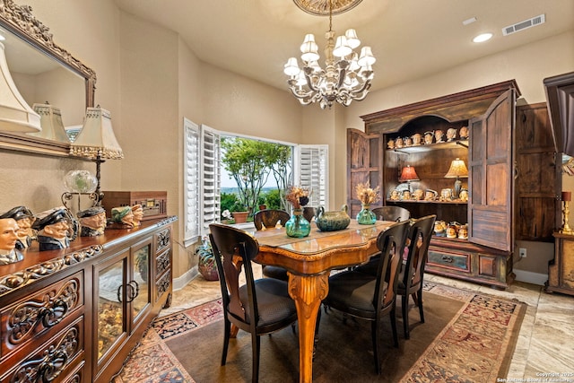 dining room with a notable chandelier, visible vents, and baseboards