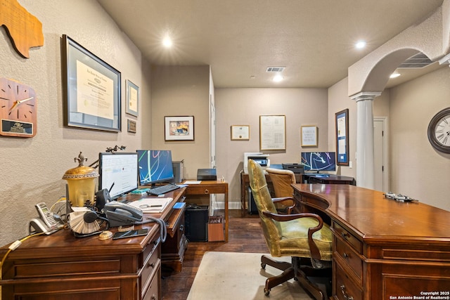 home office with dark wood-style flooring, arched walkways, recessed lighting, ornate columns, and visible vents