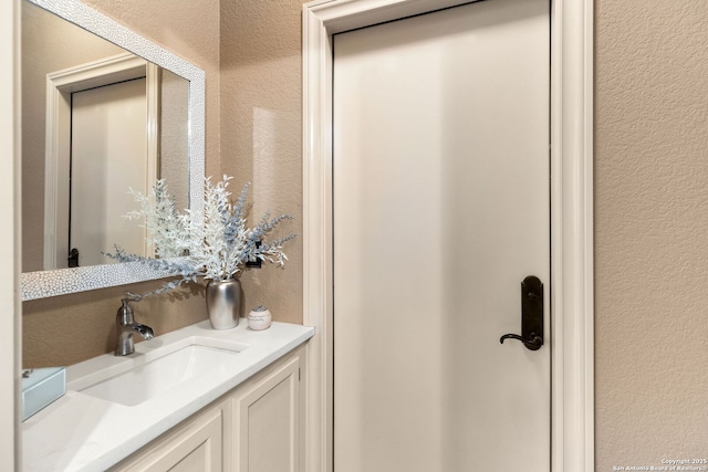 bathroom featuring vanity and a textured wall