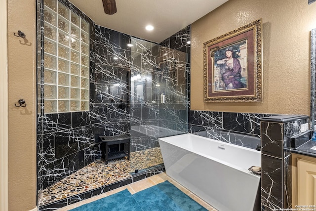 bathroom with a textured wall, walk in shower, and a soaking tub