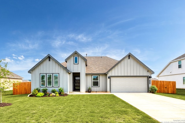 modern farmhouse featuring fence, a front lawn, a garage, board and batten siding, and driveway