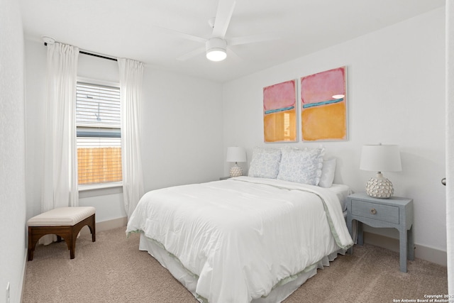 bedroom with baseboards, ceiling fan, and light carpet