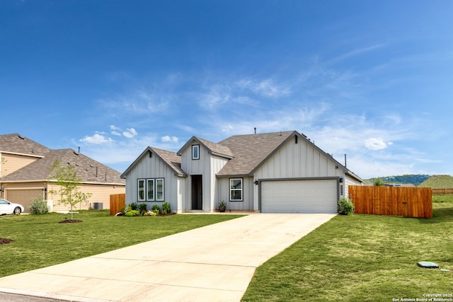 view of front of home featuring a shingled roof, a front lawn, board and batten siding, and fence