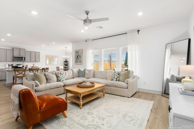 living area with plenty of natural light, ceiling fan with notable chandelier, recessed lighting, and visible vents