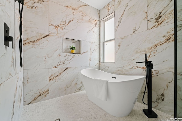 bathroom featuring a freestanding bath and tile walls