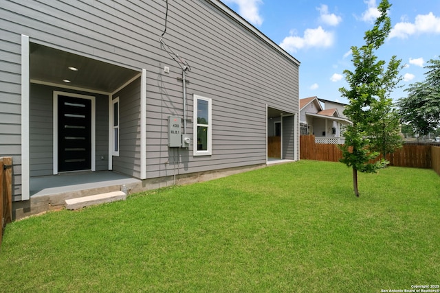back of house featuring a lawn and fence
