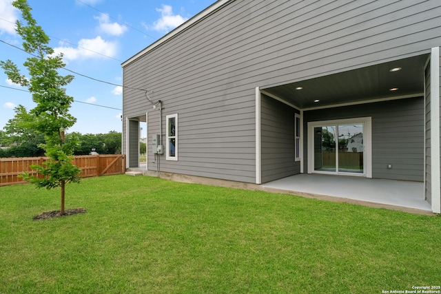 back of property featuring fence, a patio, and a yard