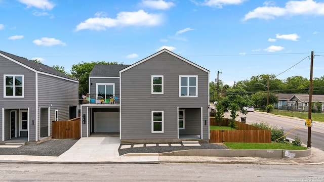 view of front of home with fence, driveway, and a garage