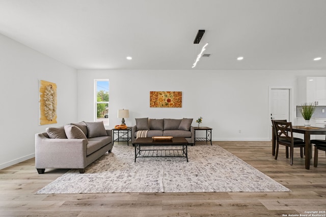 living room featuring baseboards, recessed lighting, and wood finished floors