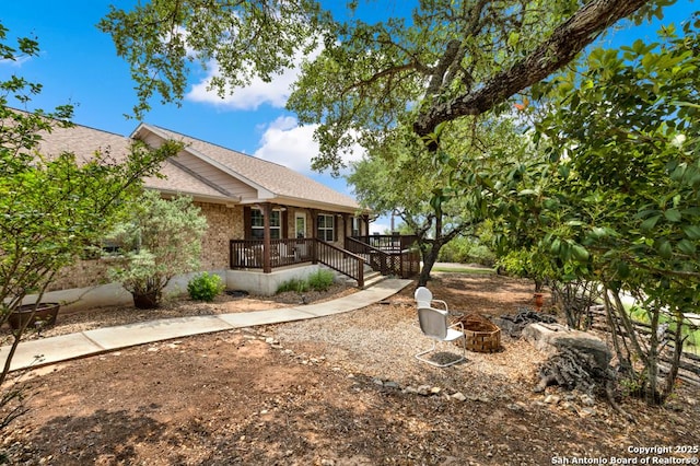 view of yard with covered porch and an outdoor fire pit