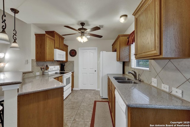 kitchen featuring white appliances, ceiling fan, a sink, a peninsula, and backsplash