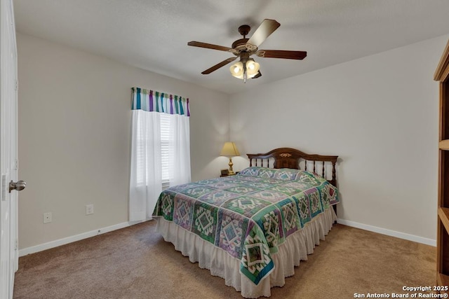 bedroom featuring light colored carpet, baseboards, and a ceiling fan